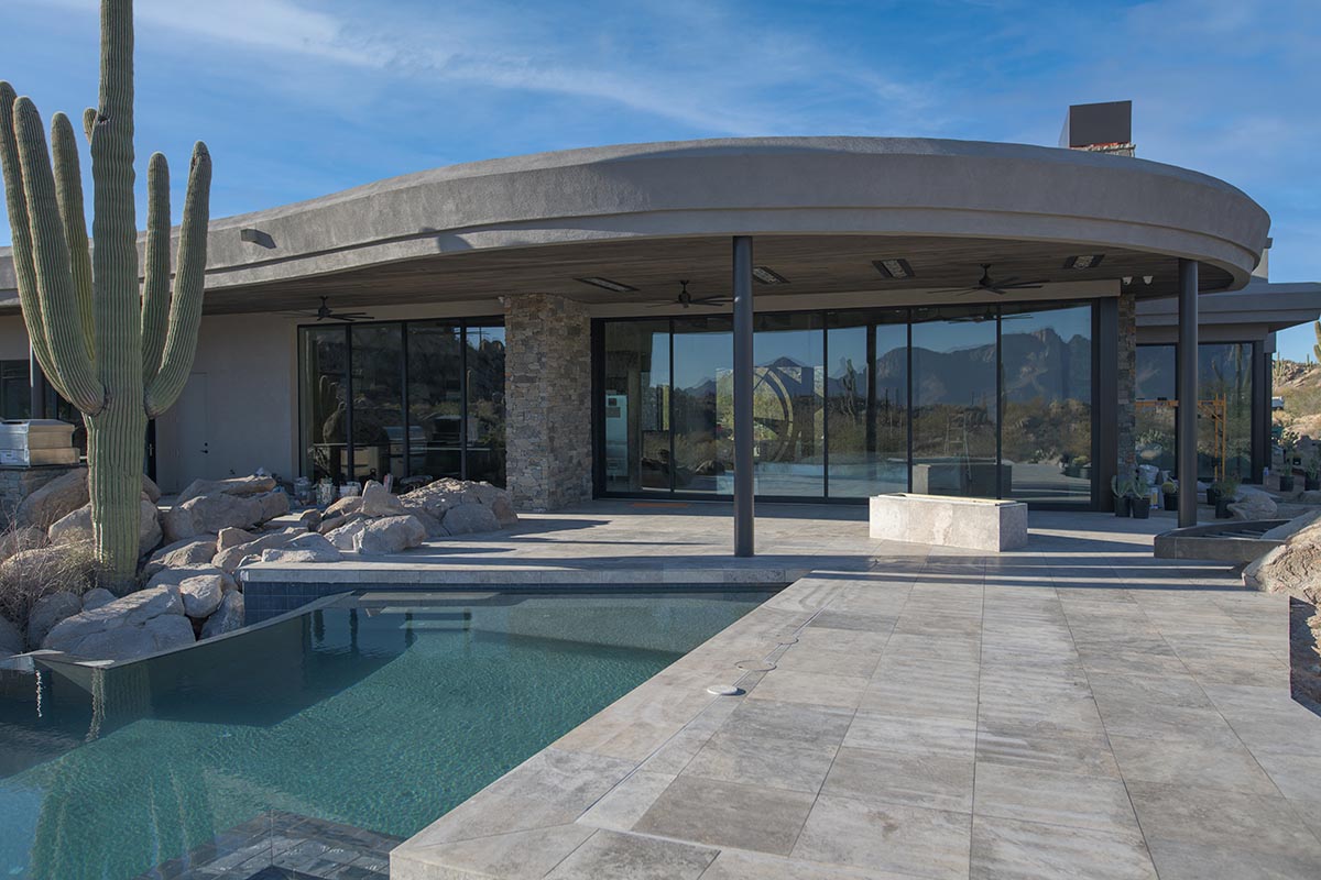 backyard of a an Arizona home with a pool & a wall of windows