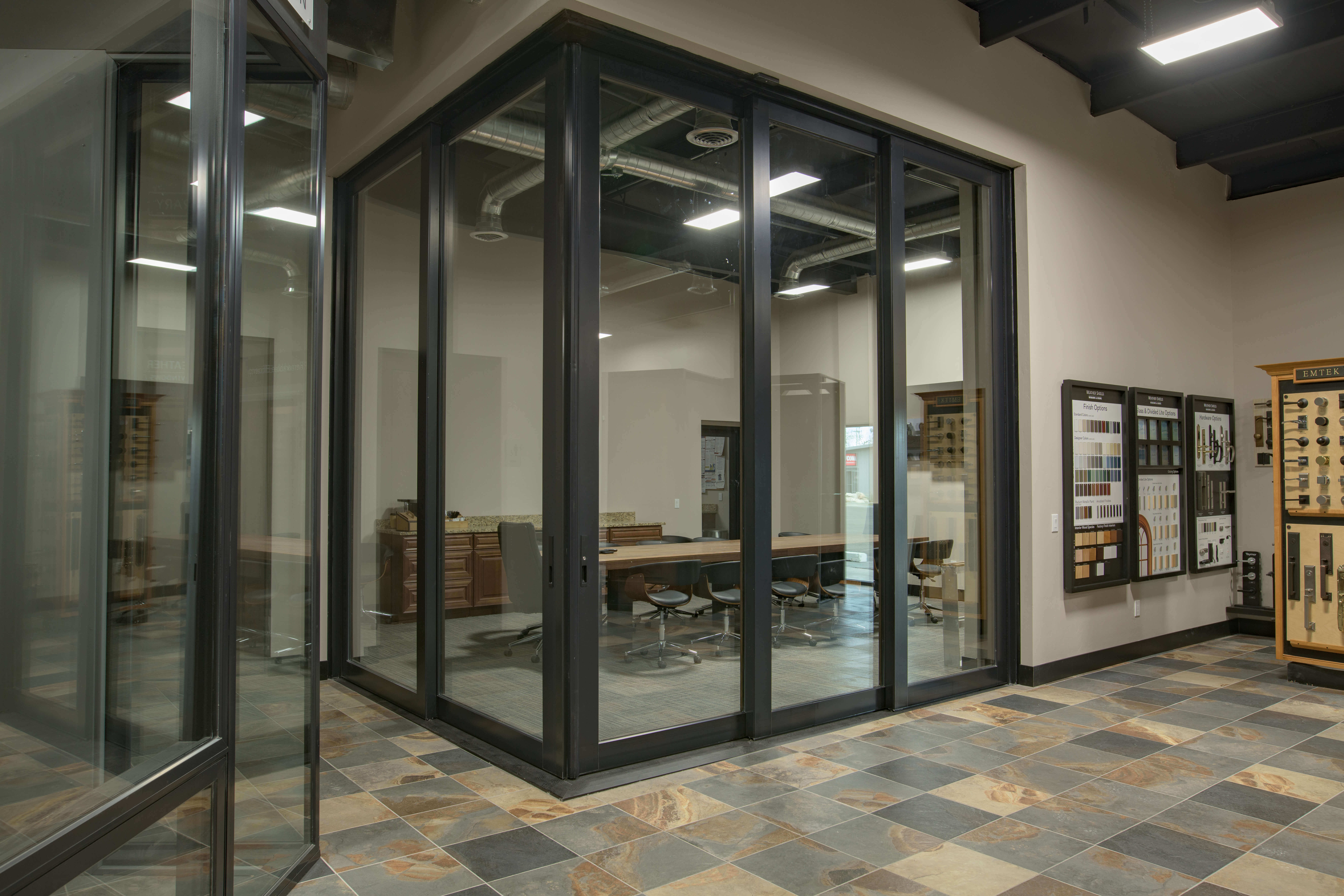 Glass doors and a desk in a room with commercial transform windows.